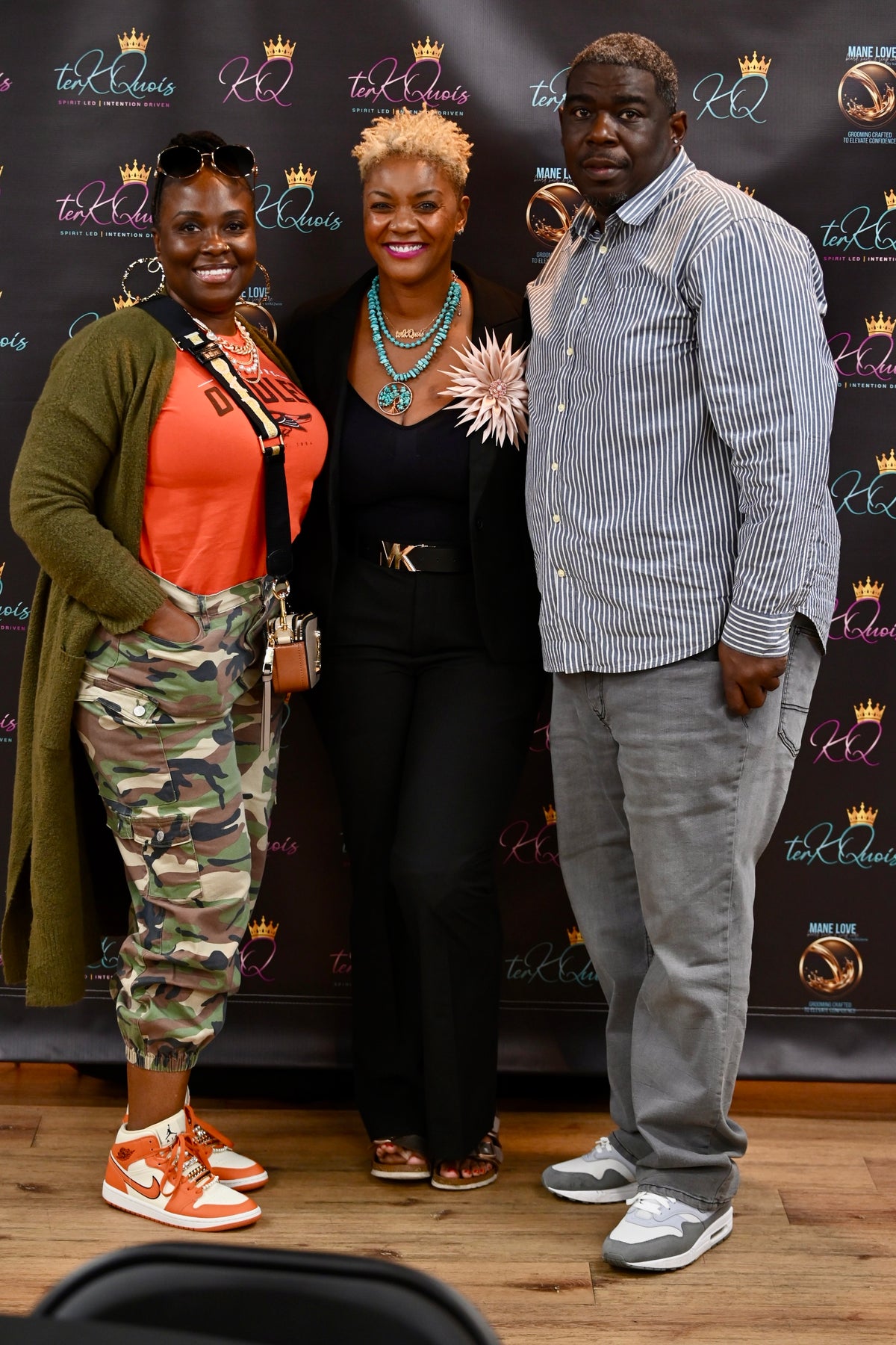 Three people posing against a backdrop | Terkquois
